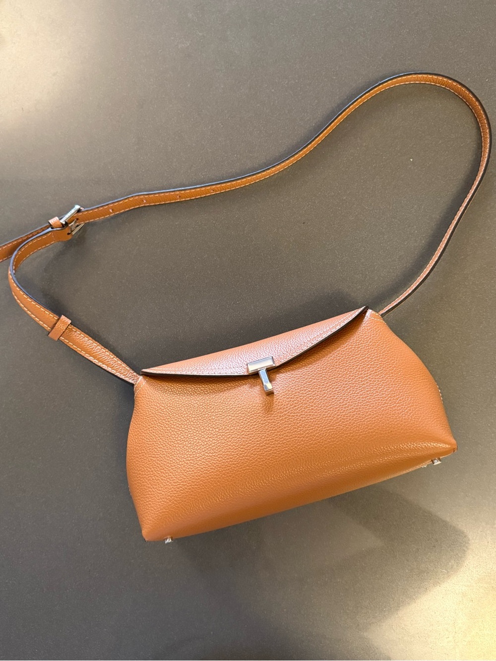 Toteme T-Lock brown leather clutch bag.